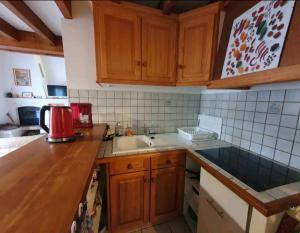 - une cuisine avec des placards en bois et un comptoir dans l'établissement Maison idéalement située pour 6 personnes, à Soustons