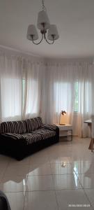 a living room with a large couch in front of curtains at Cozy house Ioannina neokesaria in Neokaisáreia