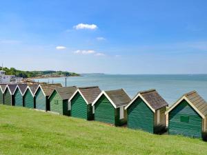 uma fileira de cabanas de praia numa colina junto à água em Holiday chalet Cowes Isle of Wight em Gurnard