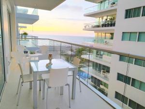 een balkon met een tafel en stoelen en uitzicht op de oceaan bij Morros 3 Apartamentos de Lujo in Cartagena