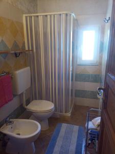 a bathroom with a shower and a toilet and a sink at Appartamento Il Salice in Casa Minnina +16 photos