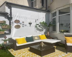 a patio with a white couch and yellow pillows at Beaucliffe continental in Blackpool