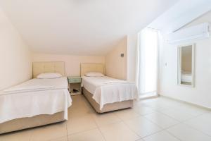 two beds in a room with a window at Apartments Near to City Center and Beach in Marmaris