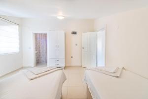 two beds in a room with white walls at Apartments Near to City Center and Beach in Marmaris