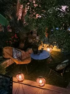 a backyard with lights and a table and chairs at And&Col Jardin ,terrasse & climatisation in Marseille