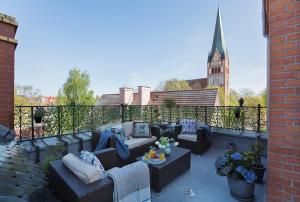 a patio with couches on a balcony with a church at Loft Barnim w wieży strażackiej, 2-poziomowy, 100m2, taras na dachu in Szczecinek