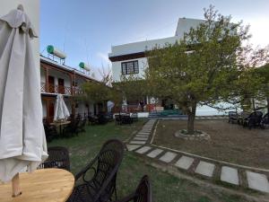 a table and chairs with a tree and a building at Hotel Kang Lha Chen in Leh