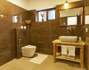 ein Badezimmer mit einem Waschbecken, einem WC und einem Spiegel in der Unterkunft Hotel Kang Lha Chen in Leh