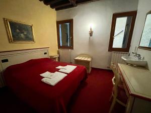- une chambre avec un lit rouge et un lavabo dans l'établissement Ai Boteri, à Venise