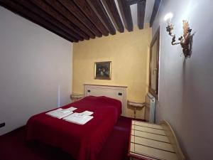 - une chambre avec un lit rouge et une chaise dans l'établissement Ai Boteri, à Venise