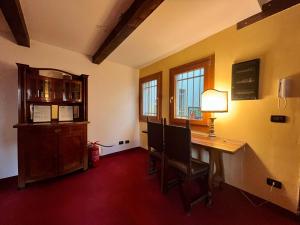 Cette chambre comprend un bureau avec une lampe et des fenêtres. dans l'établissement Ai Boteri, à Venise