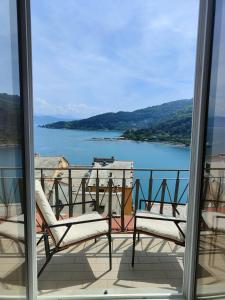 balcón con 2 sillas y vistas al lago en Byron Guest House, en Portovenere