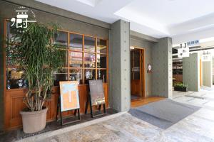 a building with a potted plant in front of it at Roots Chew Hotel in Tainan