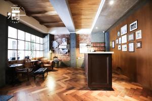 a living room with a wooden floor and a table at Roots Chew Hotel in Tainan