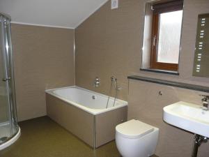 a bathroom with a tub and a toilet and a sink at Cherry Lodge in Penrith