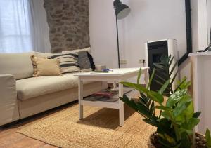 sala de estar con mesa blanca y sofá en Apartamento con encanto en el Pirineo en La Pobla de Lillet