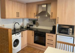 a kitchen with a washer and a stove top oven at Apartamento con encanto en el Pirineo in La Pobla de Lillet