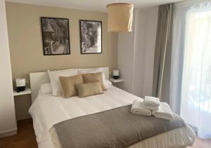 sypialnia z dużym białym łóżkiem z ręcznikami w obiekcie Apartamento con encanto en el Pirineo w mieście La Pobla de Lillet