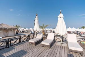 een terras met stoelen en parasols op een strand bij Oasis Resort & Spa Cozy Studio in Lozenets