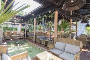 um pátio com um sofá e cadeiras e uma piscina em Oasis Resort & Spa Cozy Studio em Lozenets