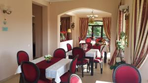 a restaurant with red chairs and tables and a window at Pensiunea Toscana in Braşov