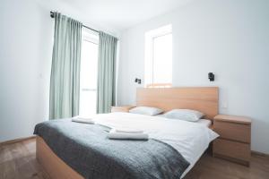 a bedroom with a large bed with two towels on it at Apartmán Vila Zuberec in Zuberec
