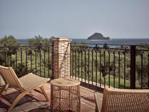 a patio with chairs and a table and a fence at Leeda's Village in Lithakia