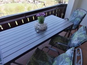 a wooden table with a potted plant on a balcony at Hölbinger Alm - Apartments in Anger