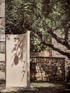 uma porta com chuveiro em frente a uma árvore em Leeda's Village em Lithakia