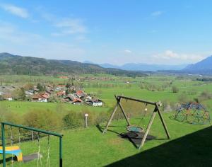 a group of swings in a field with a town at Hölbinger Alm - Apartments in Anger