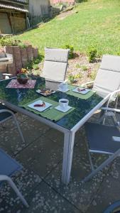 einem Glastisch mit zwei Stühlen und einem Tisch mit Essen darauf in der Unterkunft Haus Lauterberg 1 - Das Urlaubsdomizil im Harz in Bad Lauterberg