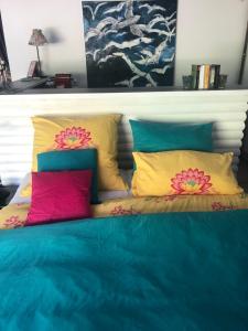 una cama con almohadas coloridas encima en HannaHs, en Salzhausen