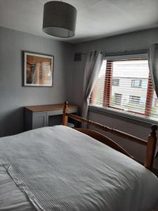 a bedroom with a bed and a window at Ella's Hoose in Wick