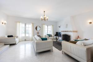 a living room with white furniture and a fireplace at CoolHouses Algarve Lagos, 4 bed single-story House, pool and amazing panoramic views, Casa Fernanda in Lagos