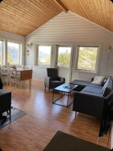 a living room with a couch and a table at Vettinghytta, close to the sea with amazing view. in Gravdal