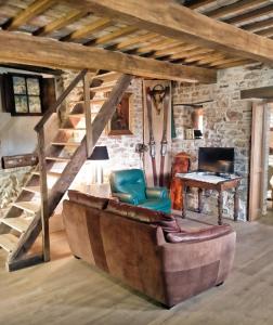 - un salon avec un canapé, une table et des escaliers dans l'établissement Maison en Pierre, à Fiastra