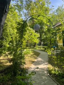 an archway in a garden with a walking path at Villa Bagolyvár in Balatonszemes