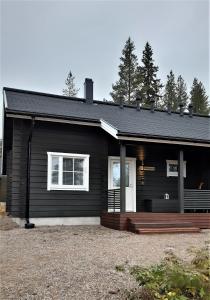 una casa negra con porche y terraza en Skicamp 3, en Pyhätunturi