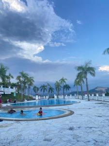 un grupo de personas en una piscina con palmeras en Spanish Villa homestay, en Senawang