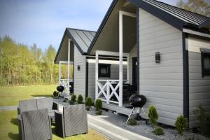 a tiny house with a porch and a grill at DOMKI SILVER 2 in Jarosławiec