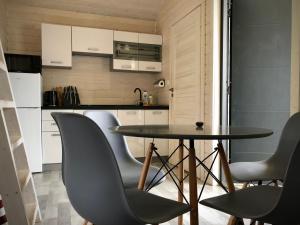 a small kitchen with a table and chairs at DOMKI SILVER 2 in Jarosławiec