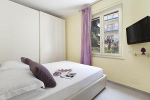 a bedroom with a white bed and a window at Estate4home - L'onda viola in Sorrento