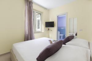 a bedroom with two white beds and a television at Estate4home - L'onda viola in Sorrento