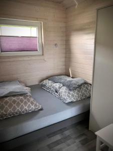 two beds in a small room with a window at DOMKI SILVER 2 in Jarosławiec