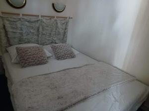 ein weißes Bett mit zwei Kissen darüber in der Unterkunft appart entierement renové les coches - la Plagne in Bellentre