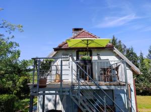 uma pequena casa com um telhado verde e uma varanda em Baldies Tenne in Ostseenähe em Wendorf