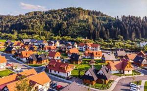 an aerial view of a village with houses and a mountain at Rezort Gothal Chalupy in Donovaly