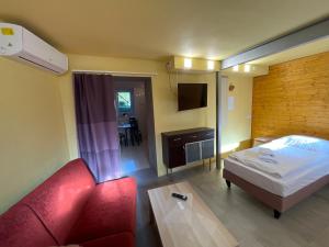 a hotel room with a red couch and a bed at Apartmány LETO in Frýdek-Místek