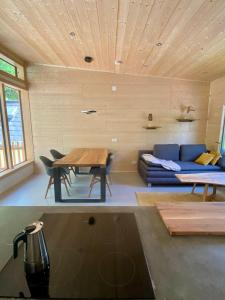 Zimmer mit einem blauen Sofa und einem Tisch in der Unterkunft Silbersberg Cottage in Gloggnitz