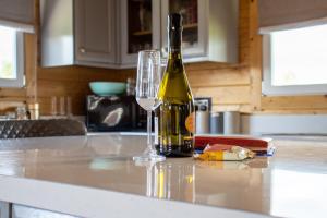 a bottle of wine and a glass on a kitchen counter at Nestledstays- The Farm Lodge in Slindon +12 photos